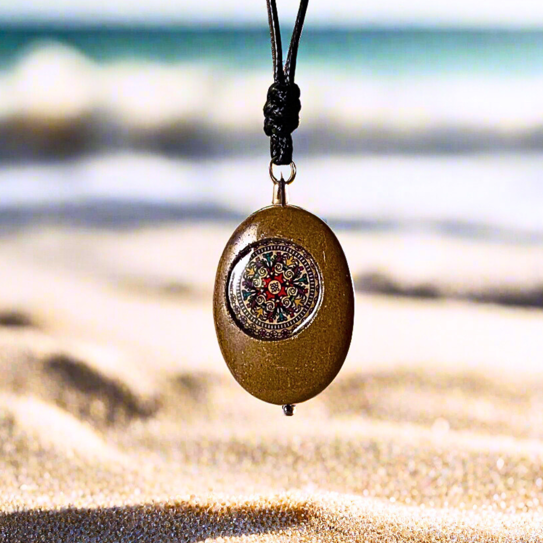 Necklace with a pendant on a sandy beach