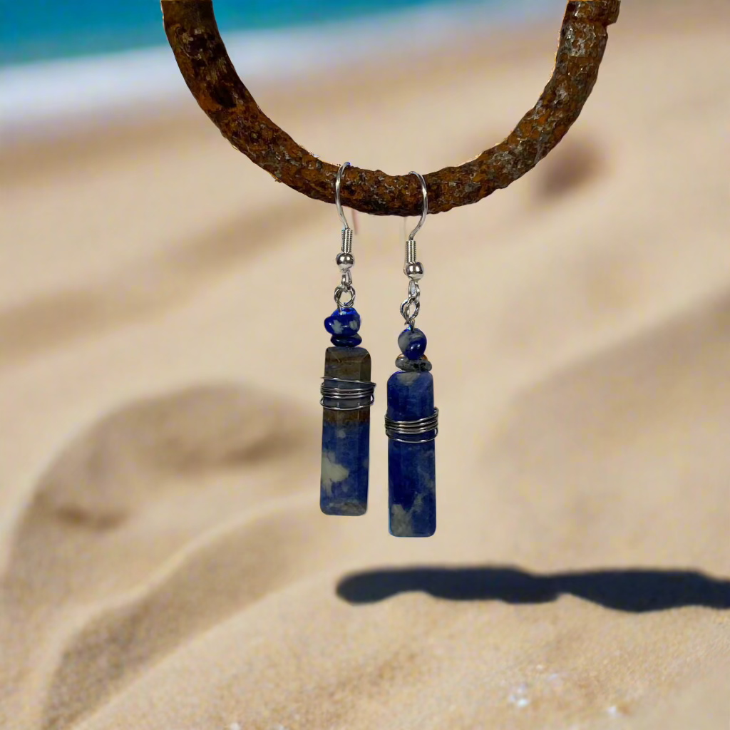 Make a statement with these stunning Blue Sodalite Trapezoidal Earrings, wrapped in sleek stainless steel and set on comfortable fish hook wires. Known for its calming energy and deep blue hues, Sodalite adds a touch of elegance and serenity to your look. Perfect for day or night!